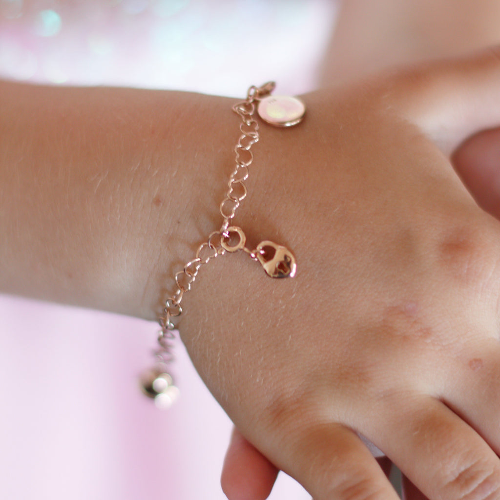 Child's hand featuring a Chain of Hearts Charm Bracelet in Rose Gold with Love Heart Lock Charm